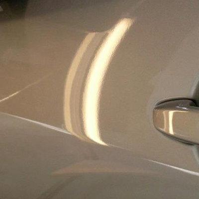white car with a repaired door dent