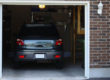 SUV car in a garage next to the entrance to a house