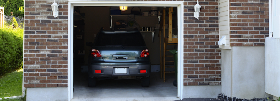 SUV car in a garage next to the entrance to a house