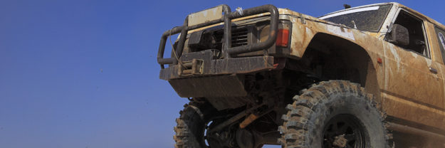 Off road car passing an obstacle.