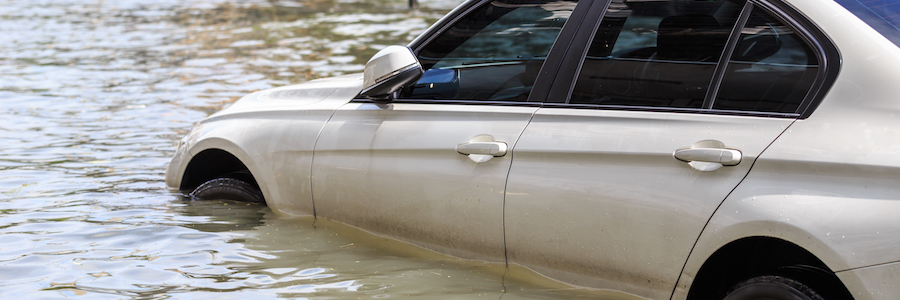 A parked car on a flooded street.