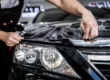Person applying protective film to a car headlight.