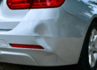 Silver sedan with dent in the back bumper.