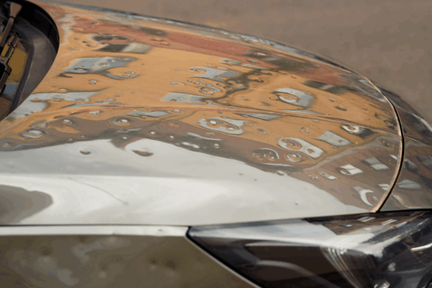 Is Paintless Dent Repair a Permanent Fix? Silver sedan with moderate hail damage on the hood.